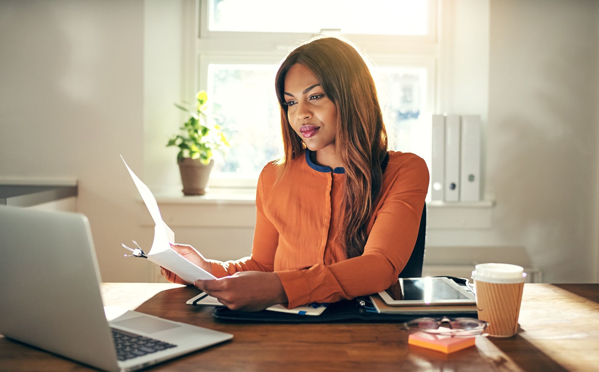 woman at laptop reviewing papers