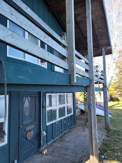 A blue house with a porch and a wooden railing.
