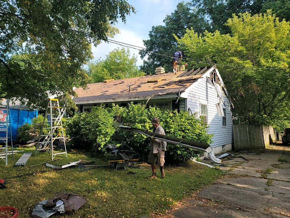 A man is standing in front of a house that is being remodeled.