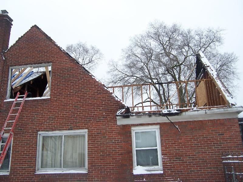 A brick house with a ladder on the side of it.
