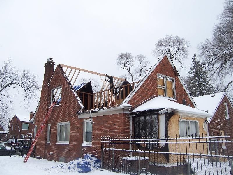 A brick house is being remodeled in the snow