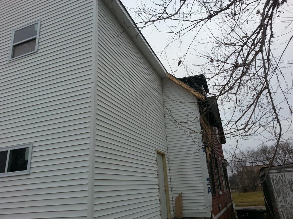 A white house with a tree in front of it
