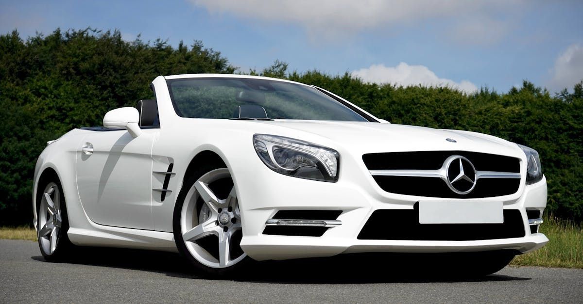 A white mercedes benz slr is parked on the side of the road.