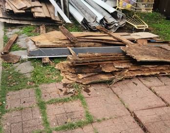 An abandoned room with a table and chairs and a sewing machine.