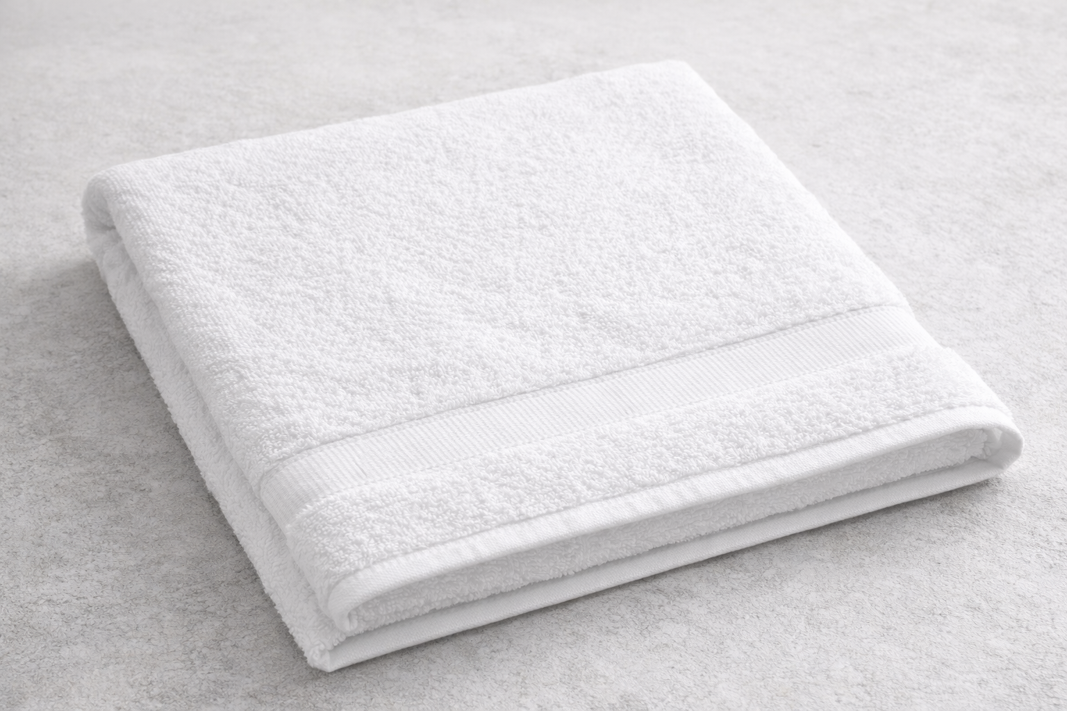 Folded white towel on a light gray surface, with a decorative band at the top.