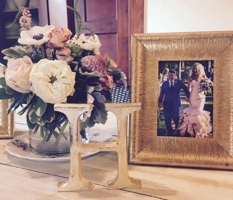 Framed photo beside a white and pink flower arrangement on a table