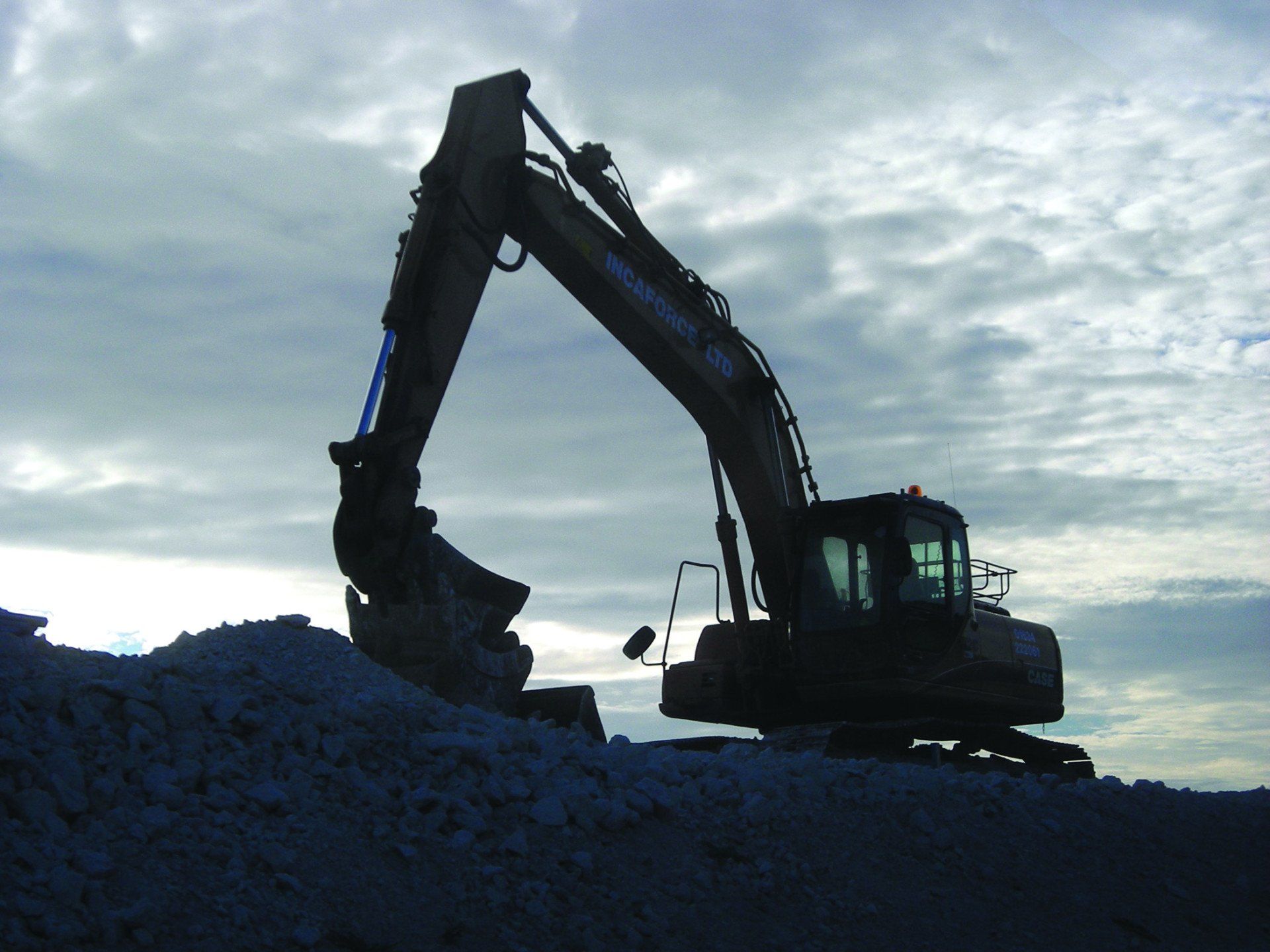A greyed-out image of a crane on a landfill site