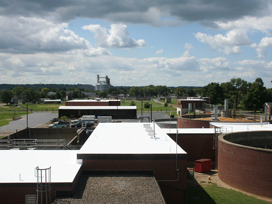 A rooftop view of a brick building with a white roof