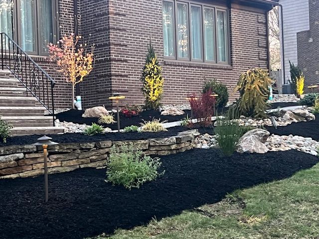 A brick house with a lush green garden in front of it.