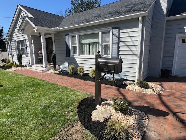 A house with a mailbox in front of it and a brick walkway.