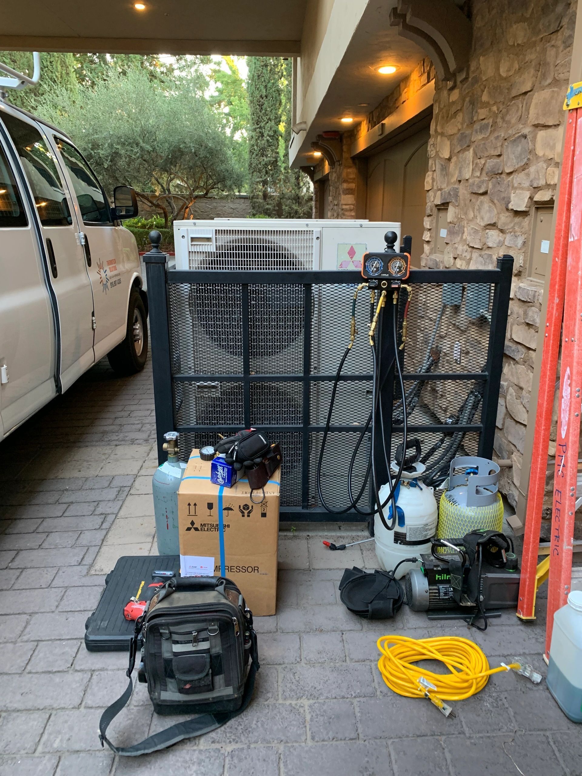 A van is parked in a driveway next to a gate.