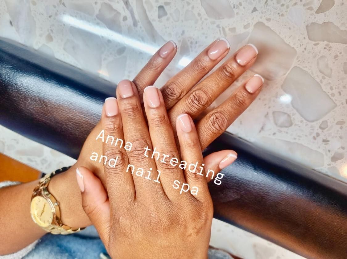 Hands with manicured nails on a black armrest at 