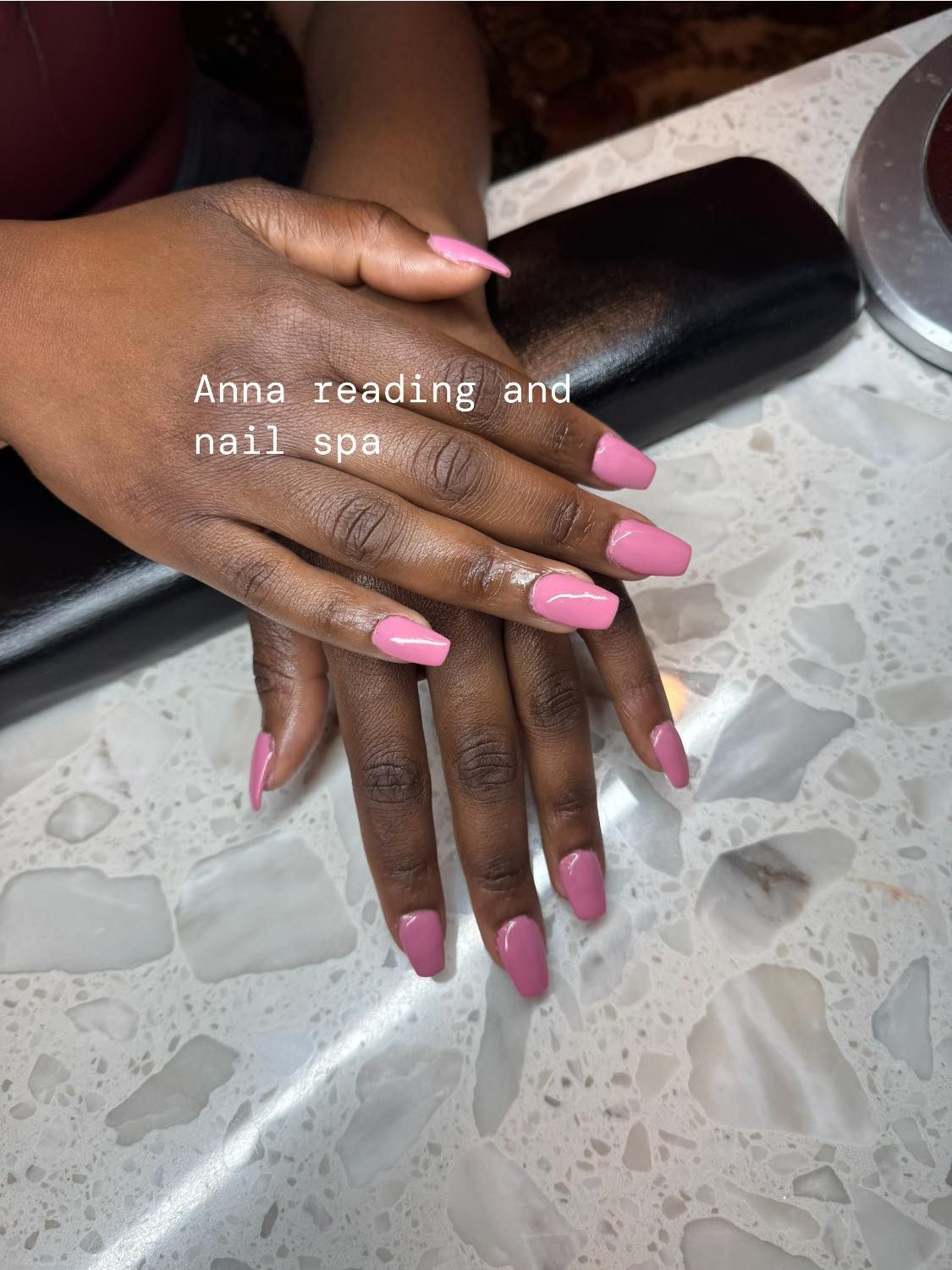 Hands with pink nail polish on a textured white surface, with text 