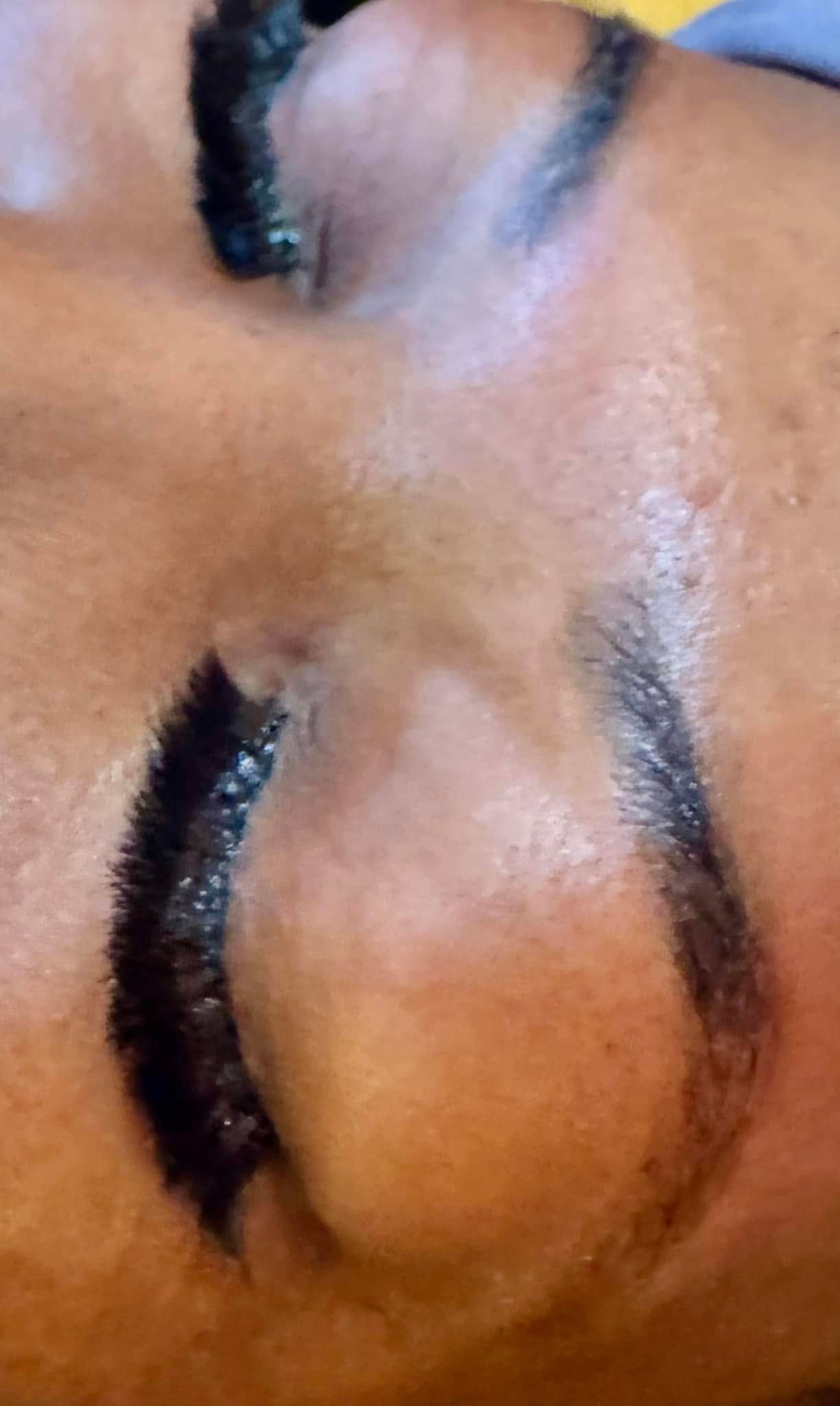 Closed eyes with dark, thick eyebrows; close-up shot.