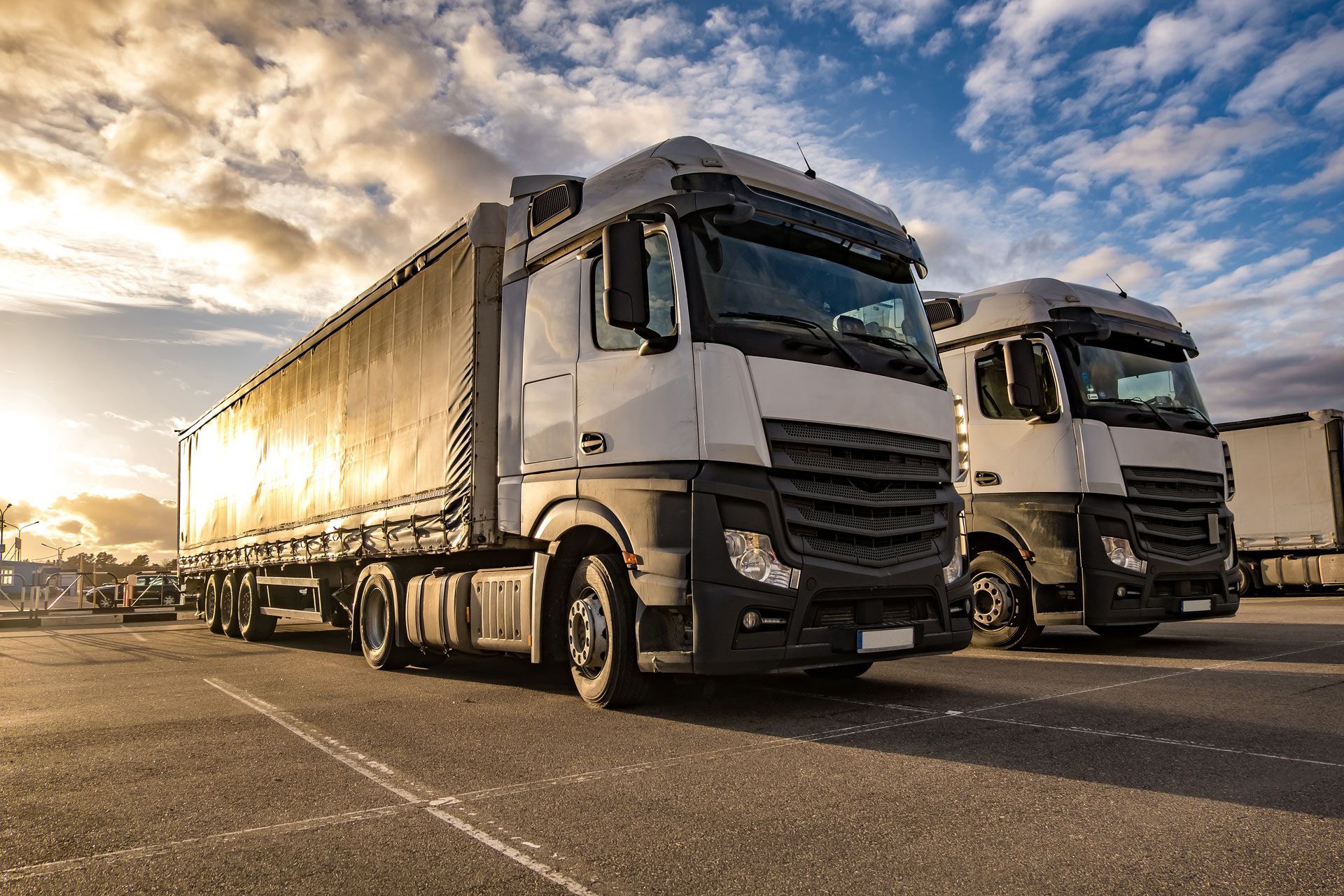 Two semi trucks are parked next to each other in a parking lot