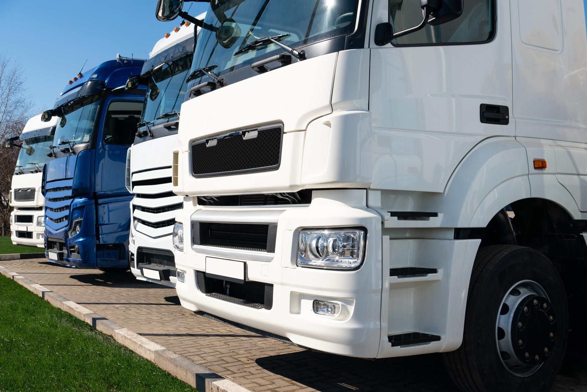 A row of semi trucks parked next to each other in a parking lot