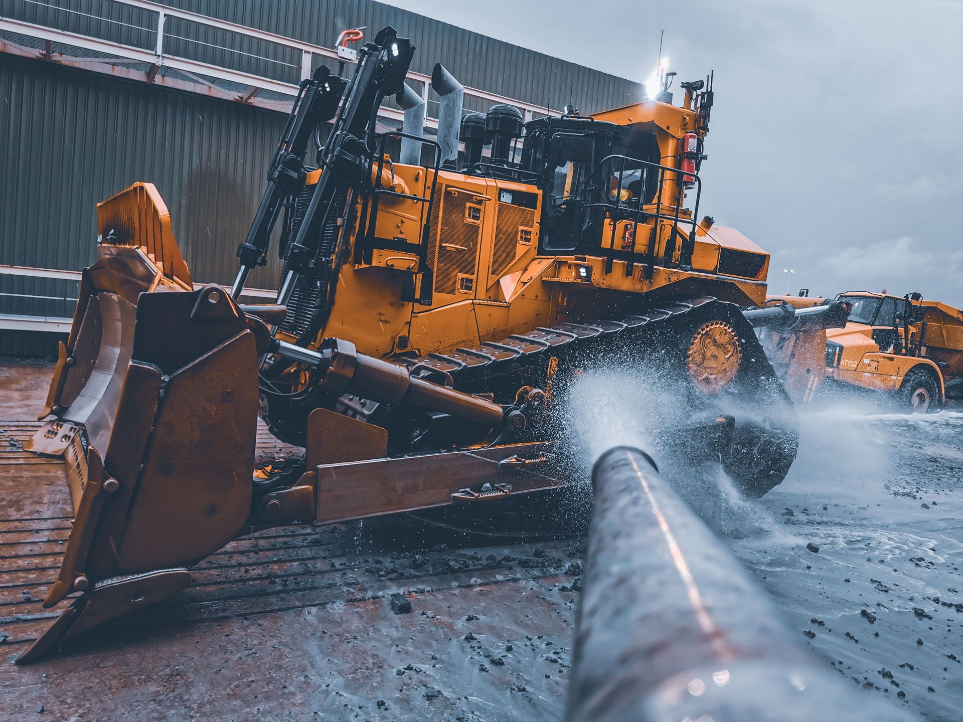 A bulldozer is spraying water on a pipe