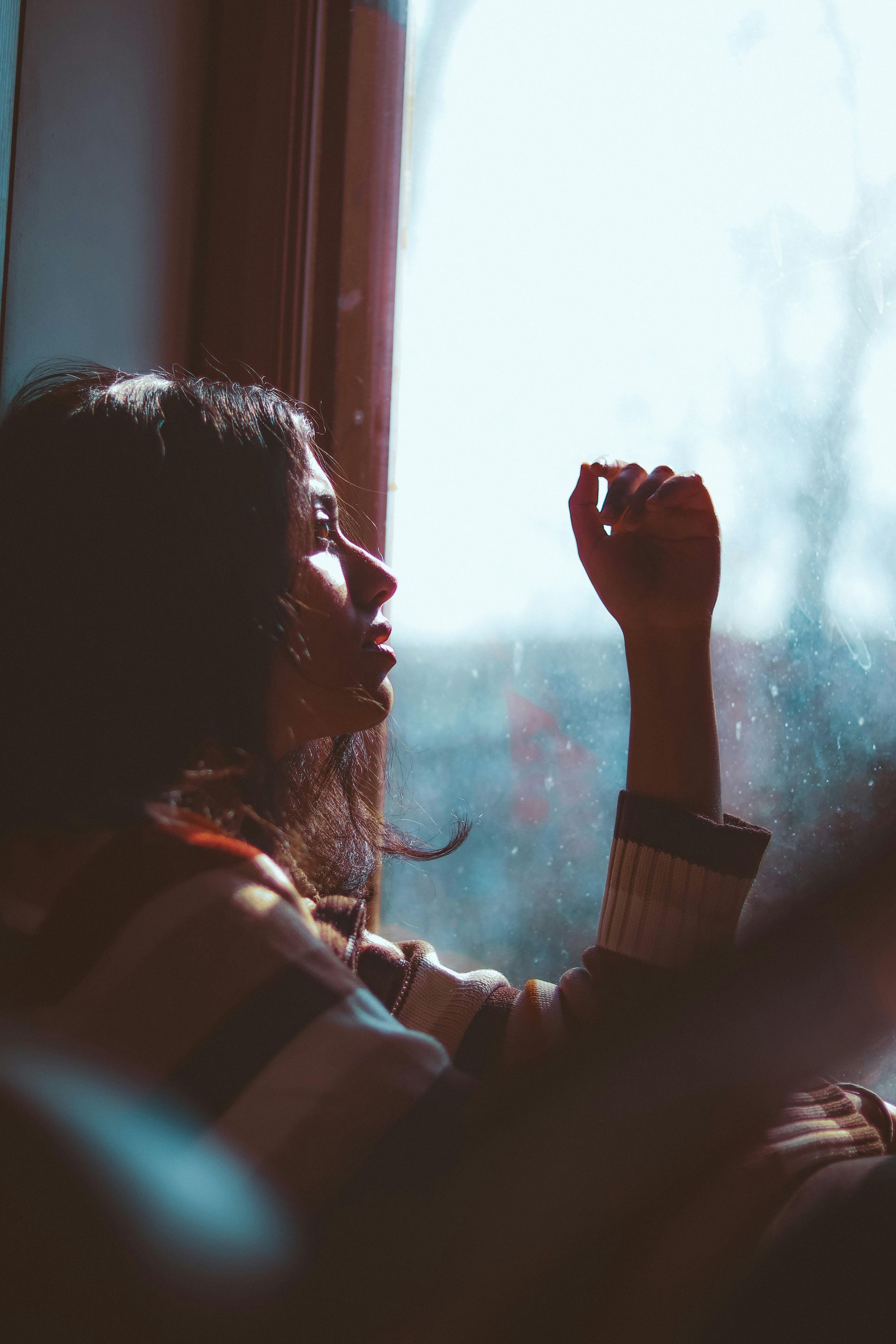 A woman is sitting on a couch talking to a man who is writing in a notebook.
