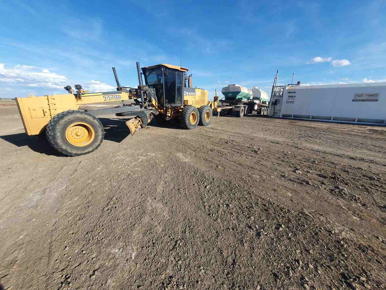 Bulldozer is Driving Down a Dirt Road Next to a Cement Truck — Burnett Contracting in Cloncurry, QLD