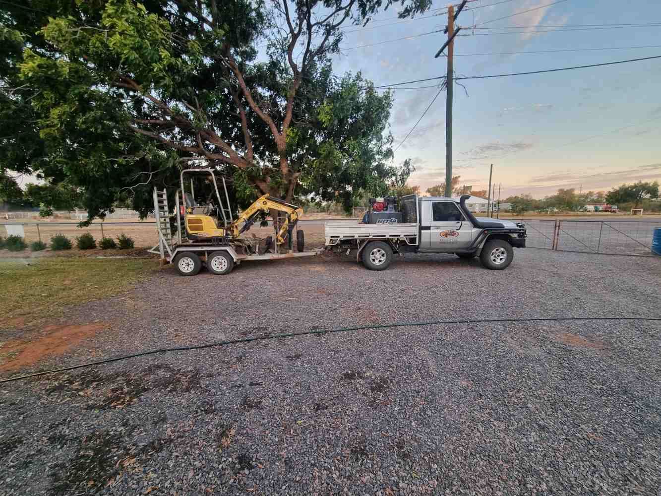 A Truck is Towing a Small Excavator on a Trailer — Burnett Contracting in Cloncurry, QLD