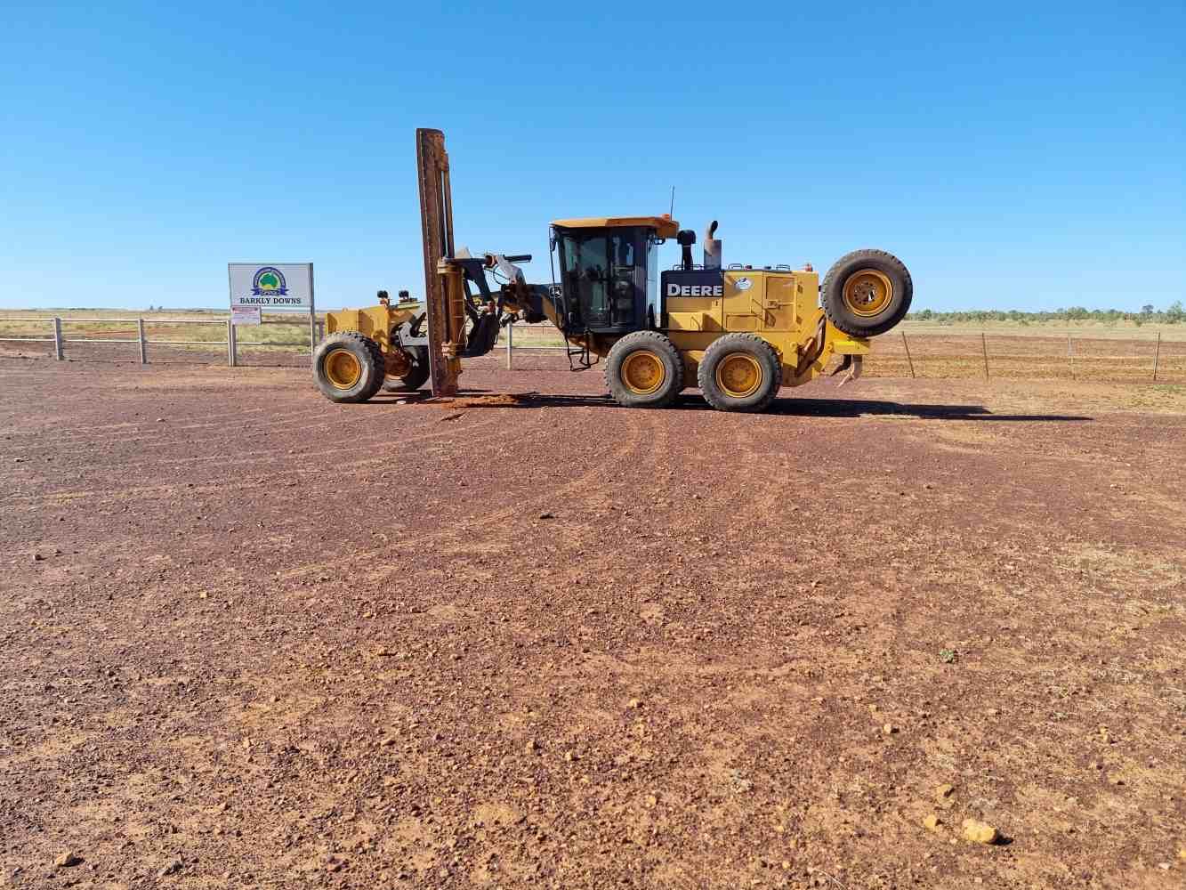 A Couple of Tractors Are Parked in a Dirt Field — Burnett Contracting in Cloncurry, QLD