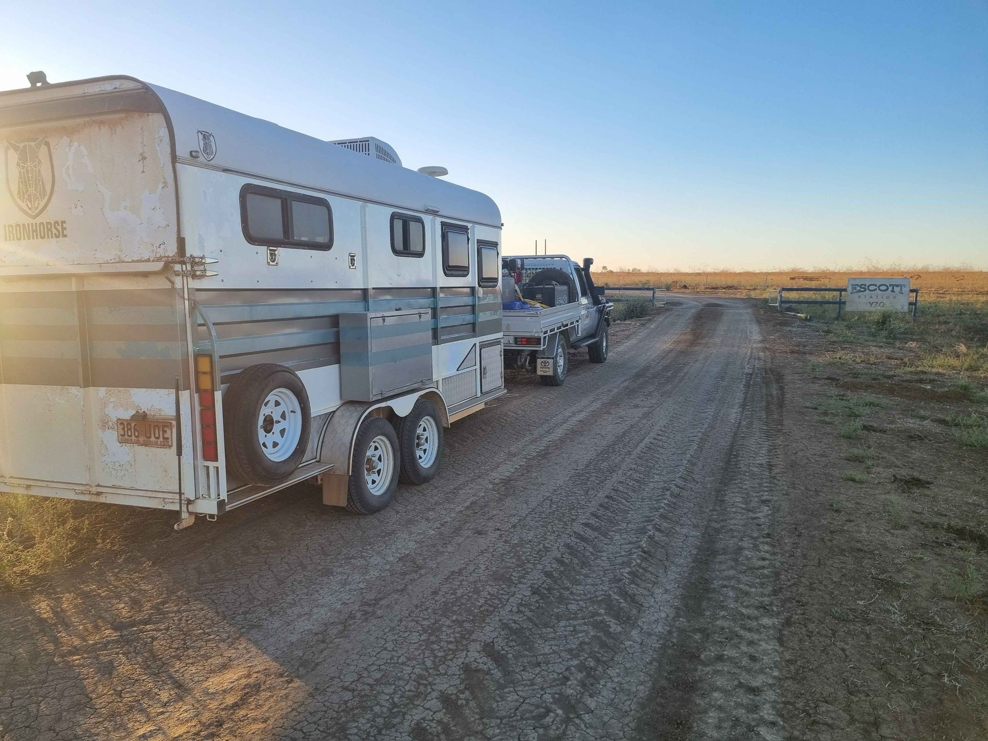 A Truck Towing a Horse Trailer on a Dirt Road at Sunset — Burnett Contracting in Mount Isa, QLD