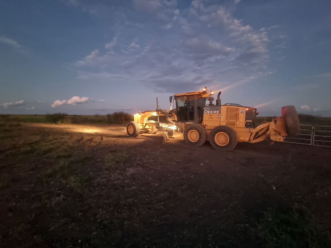A Yellow Grader Levels the Ground at Dusk — Burnett Contracting in Cloncurry, QLD