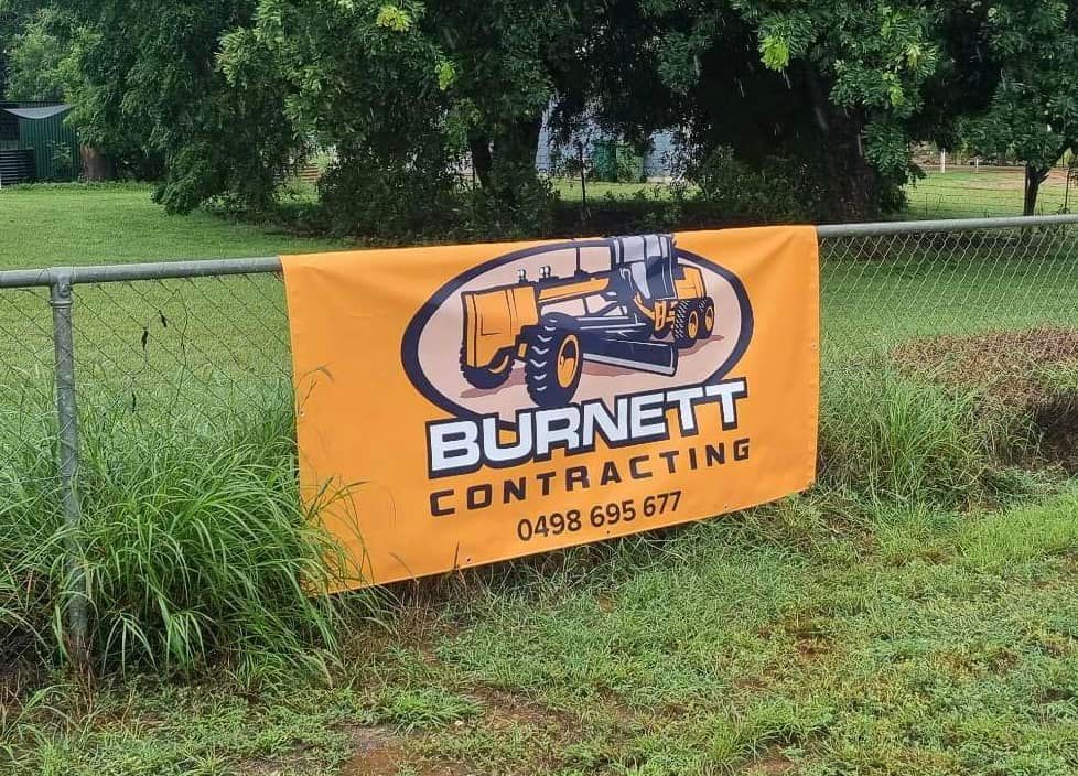 Orange Burnett Contracting Signage on a Fence With Graphic and a Phone Number — Burnett Contracting in Cloncurry, QLD