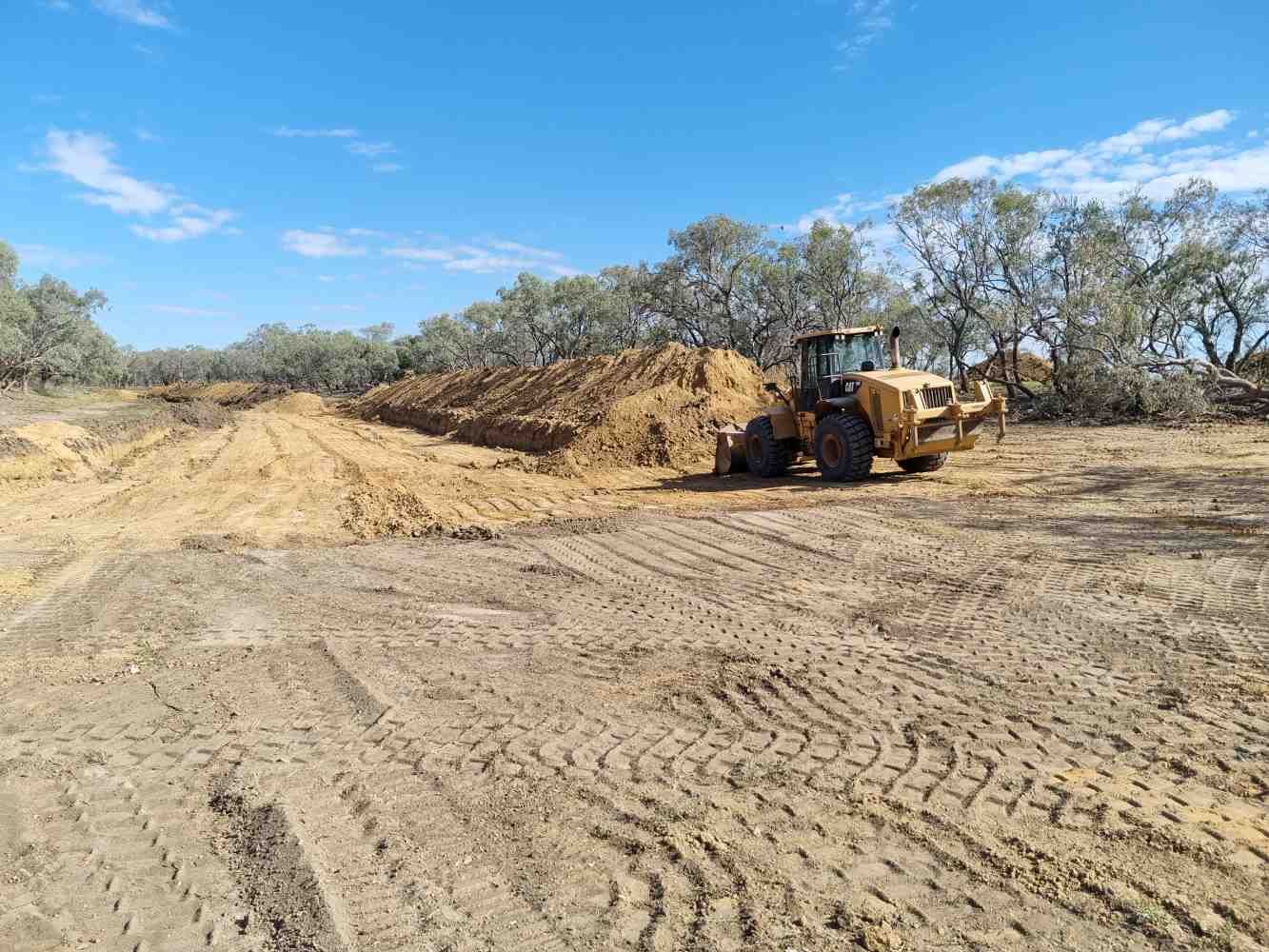 A Bulldozer is Moving Dirt in a Dirt Field — Burnett Contracting in Cloncurry, QLD