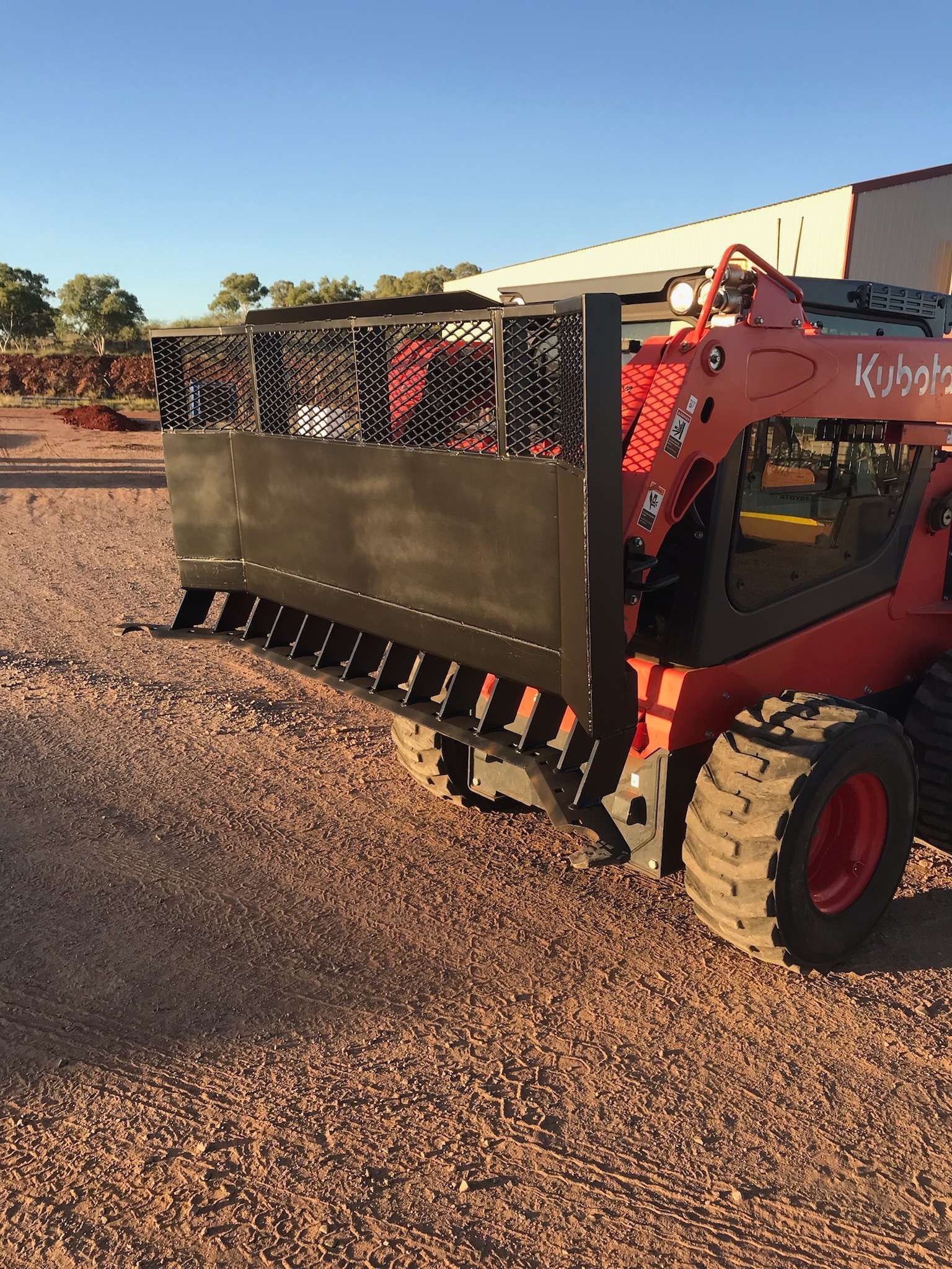 Orange Kubota Skid Steer With a Black Attachment Outdoors — Burnett Contracting in Cloncurry, QLD