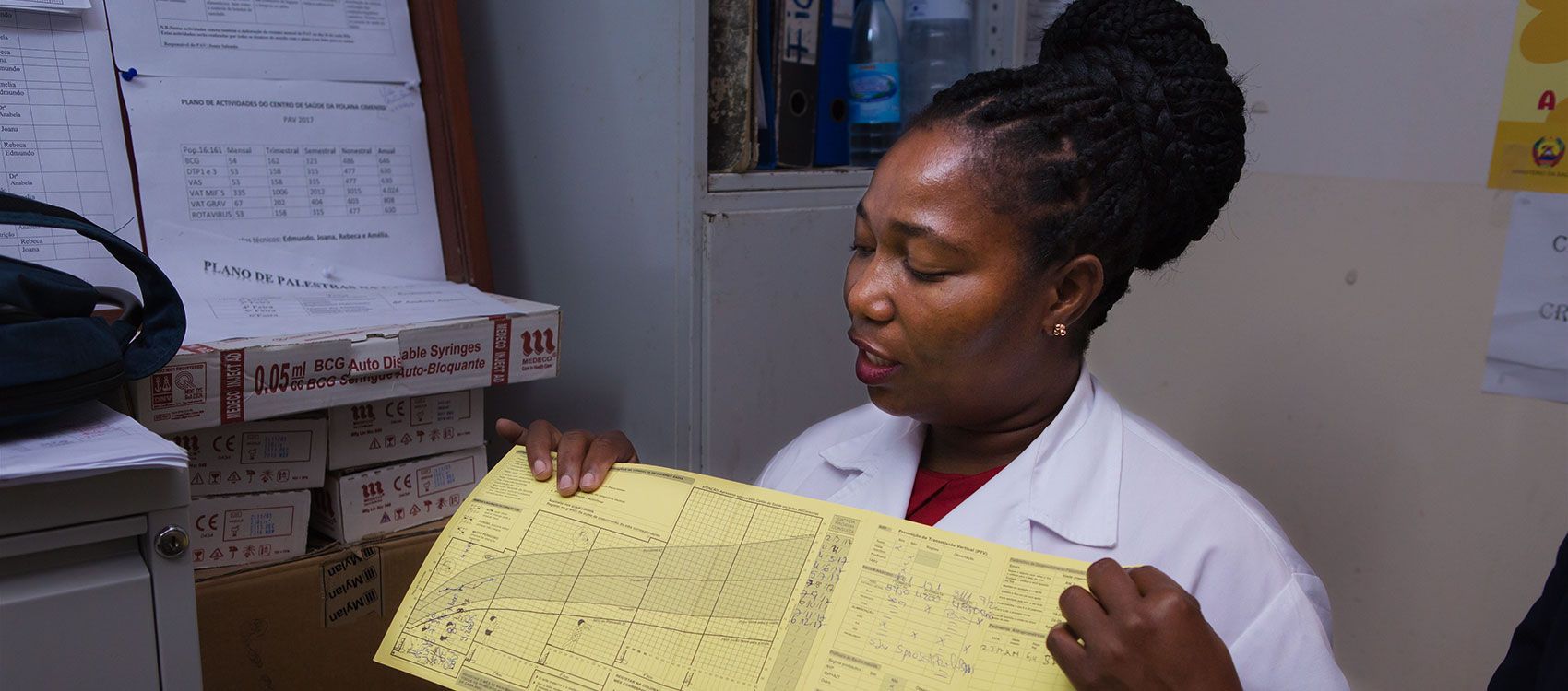 A woman in a lab coat is holding a piece of paper.