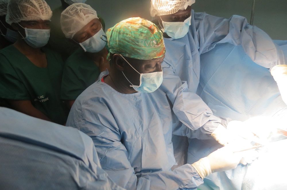 A group of surgeons are operating on a patient in an operating room.