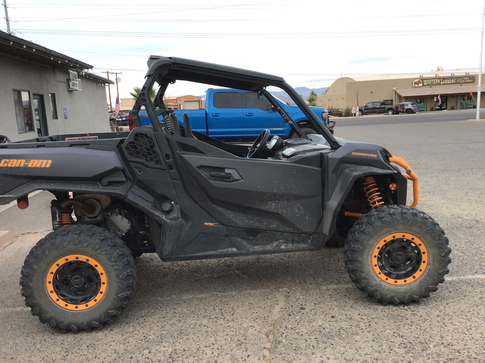 A black and orange atv is parked in a parking lot in front of a building.