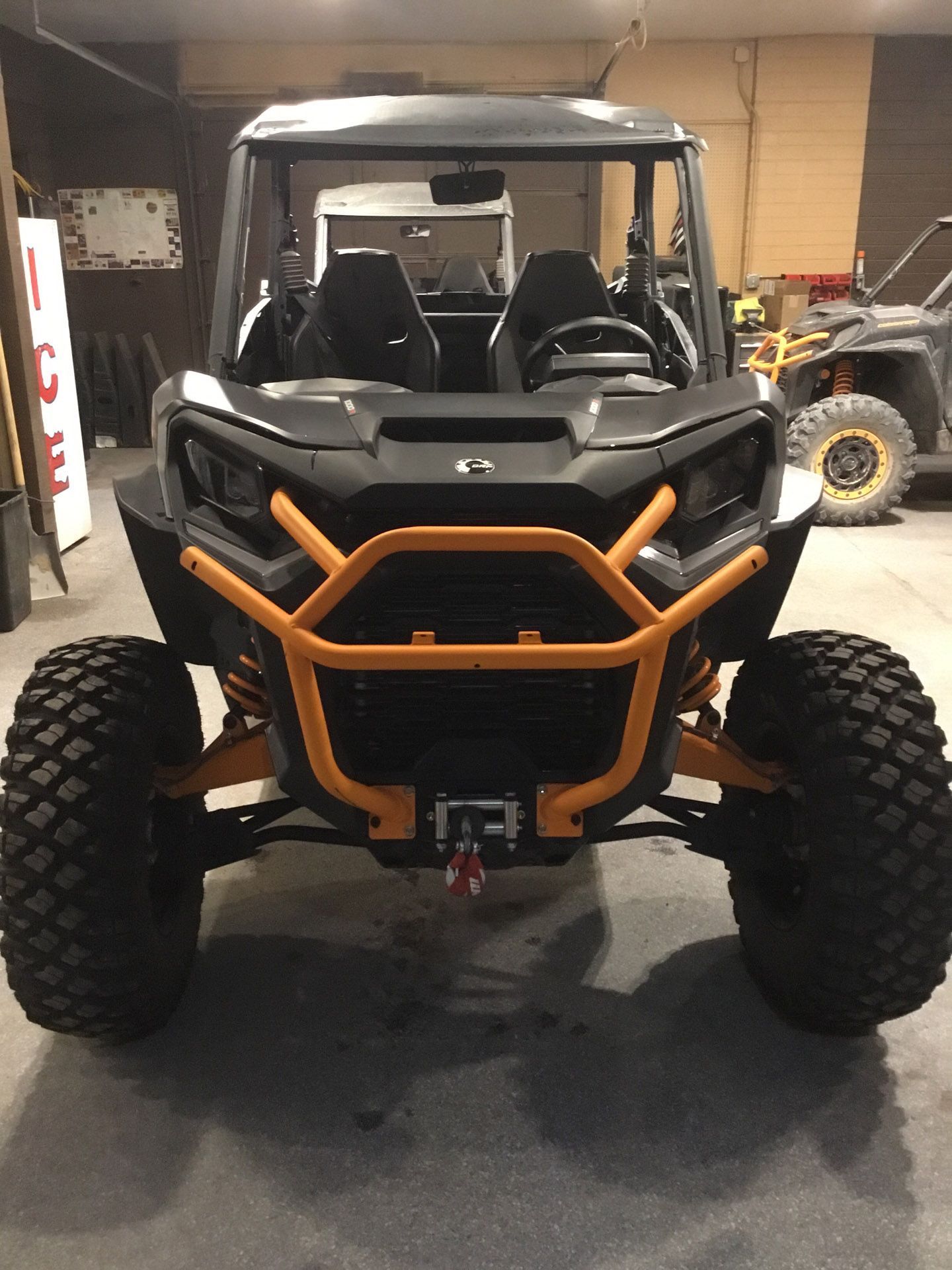 A black and orange atv is parked in a garage.