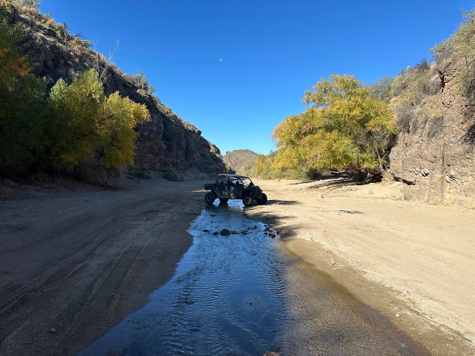 A group of people are riding atvs down a dirt road.