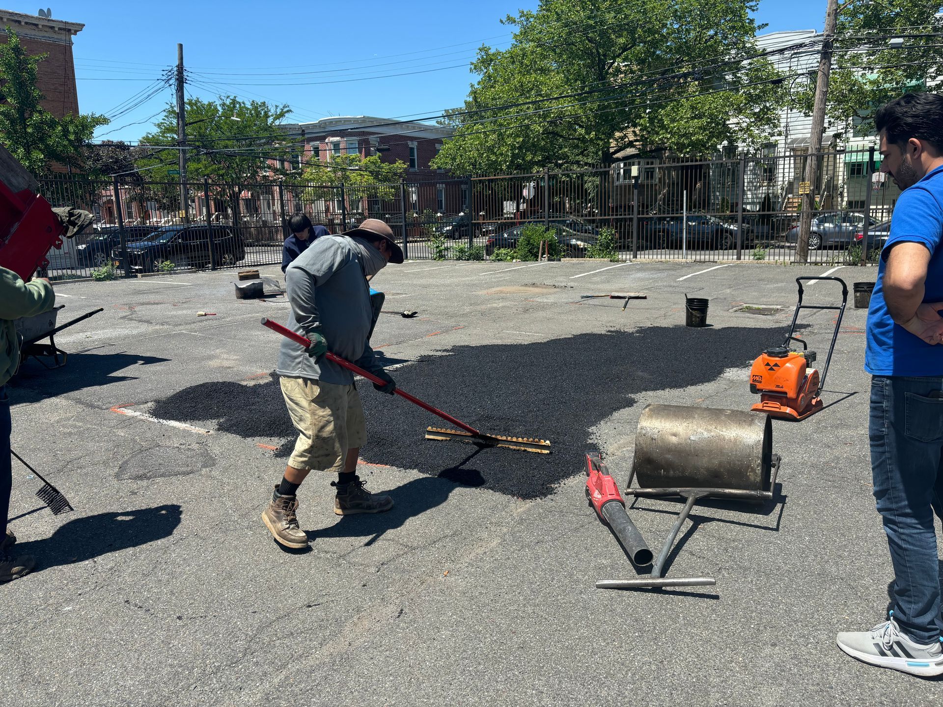 A yellow and red roller is rolling asphalt on a road.