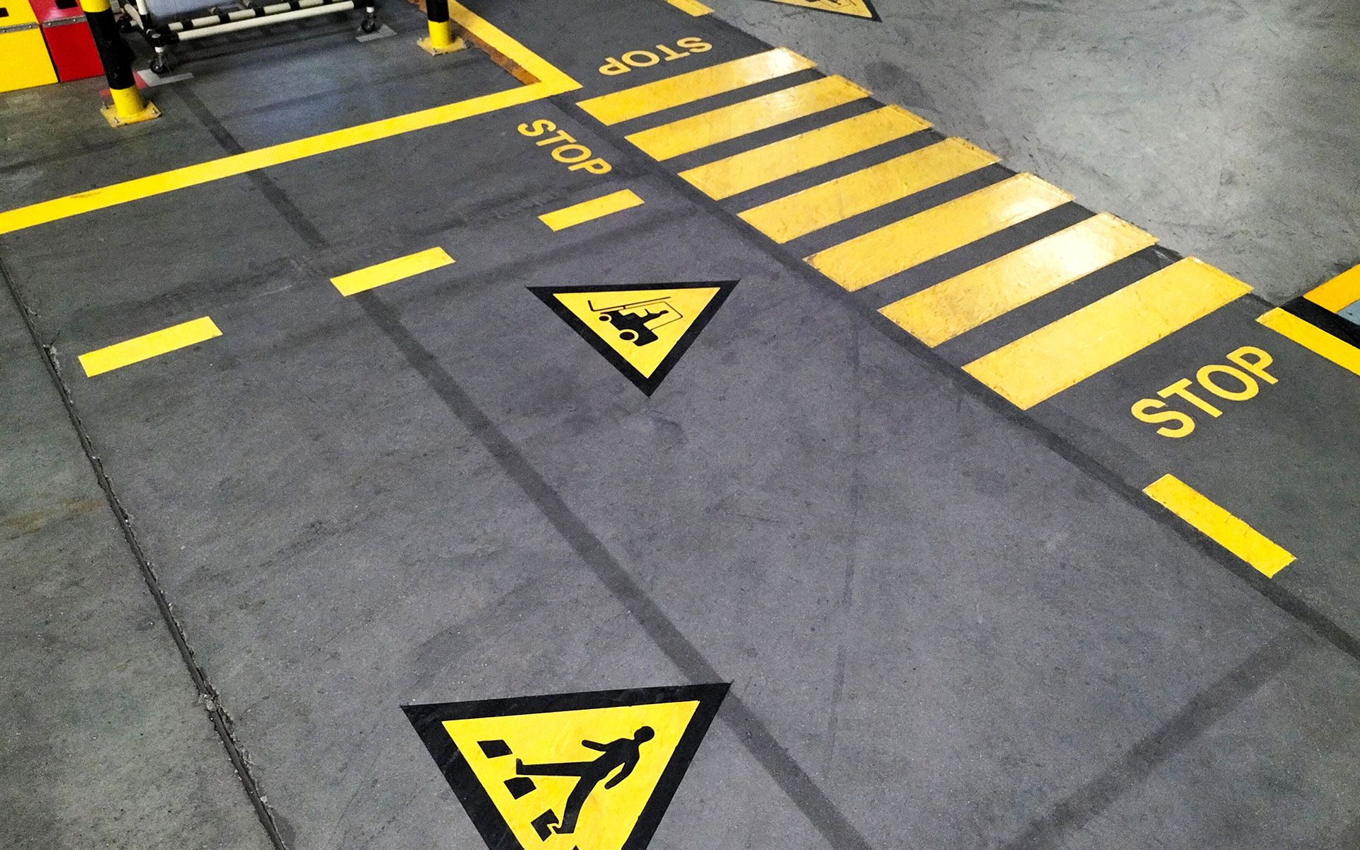A warehouse floor with yellow and black stripes and a stop sign