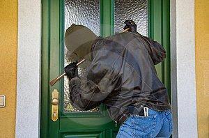 Een man probeert met een hamer in te breken in een huis.