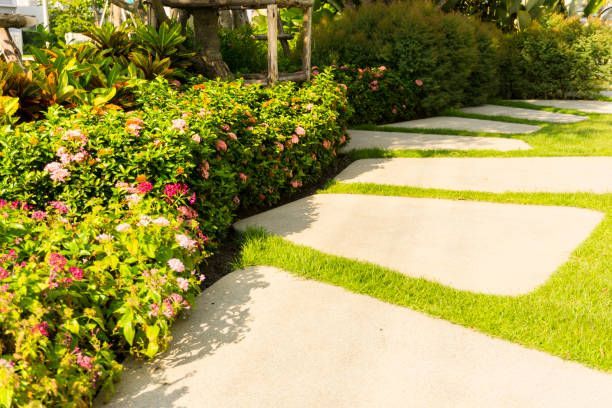 A Concrete Walkway in a Garden Surrounded by Flowers and Grass — Hackensack, NJ — MC Greenfield Tree & landscape Service LLC