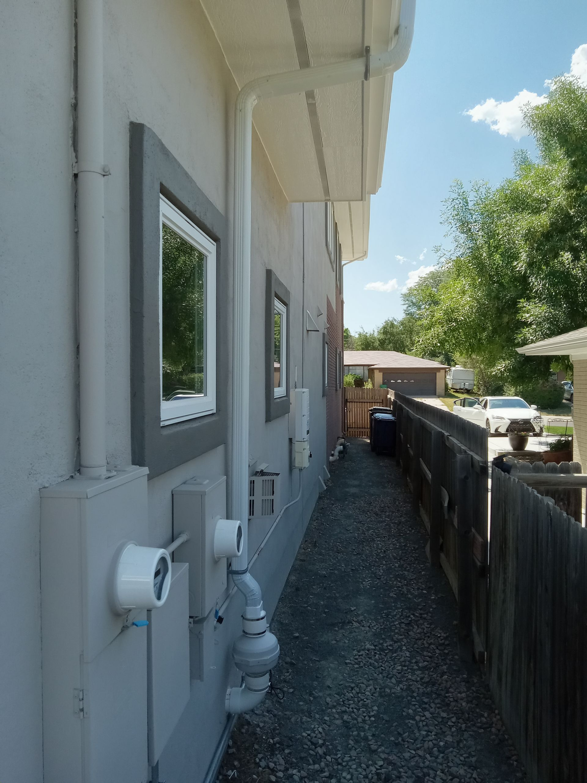 A sidewalk leading to a house with a fence in the background