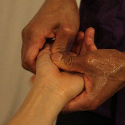 a person is giving a massage to another person's hand