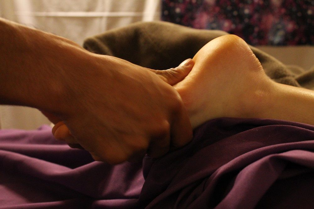 a person 's foot is being massaged on a bed