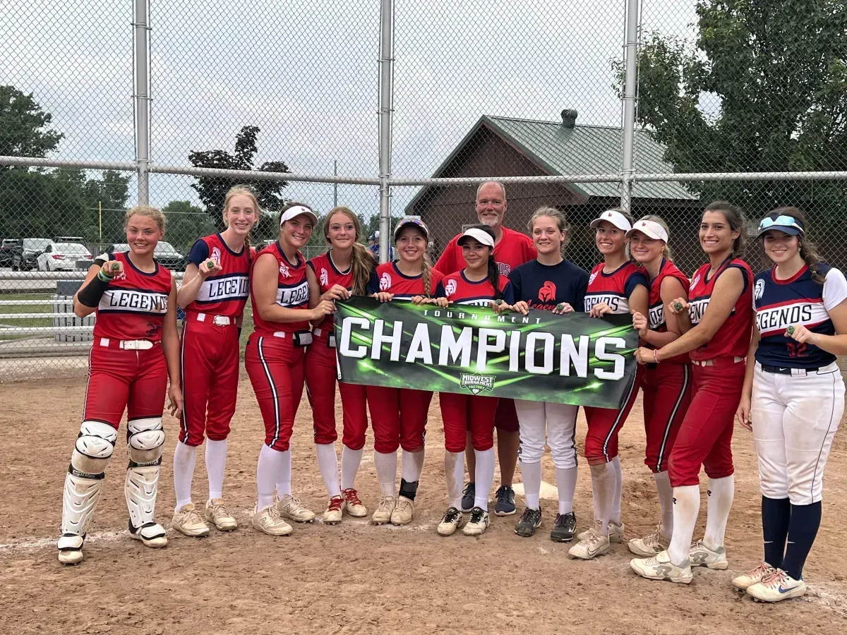 Legends Athletics softball team holding a championship banner