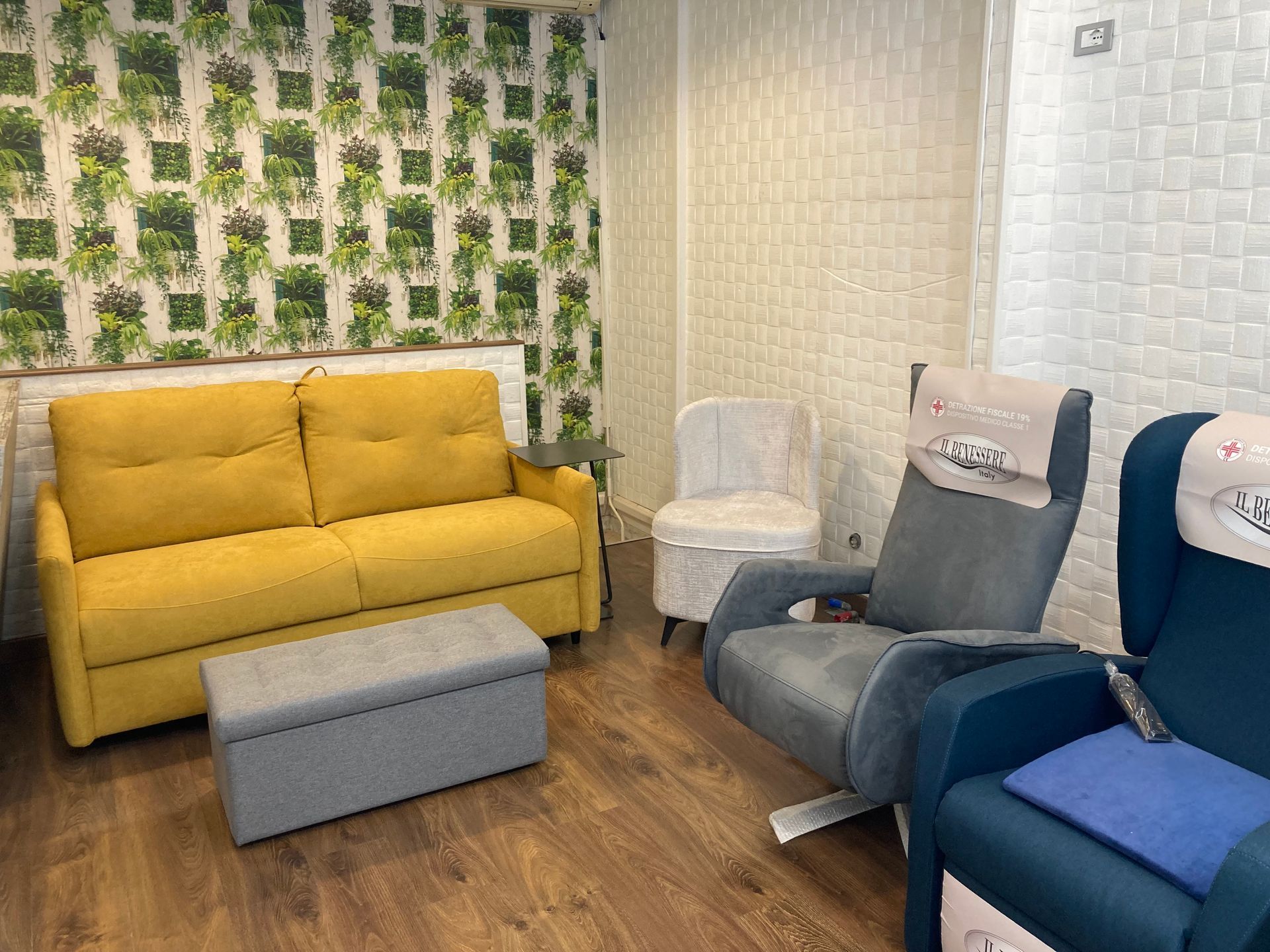 showroom con divano giallo e poltrone grigie e blu