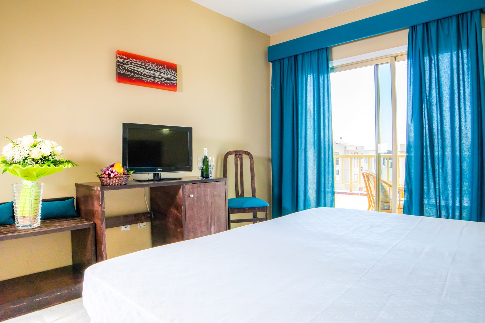 Una habitación de hotel con cama, escritorio, silla y televisión.