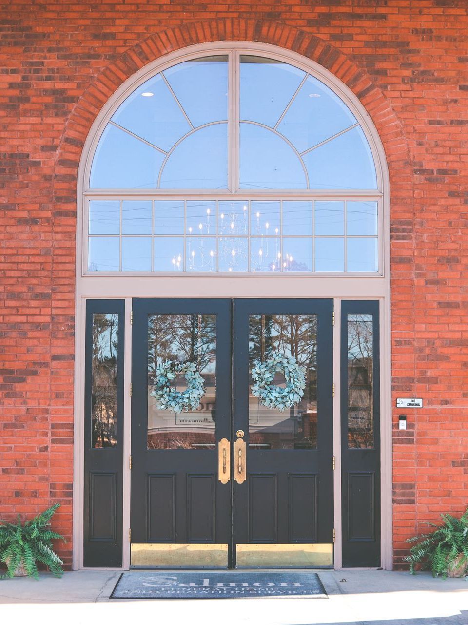 A wooden walkway leading to a gazebo overlooking a body of water at sunset.