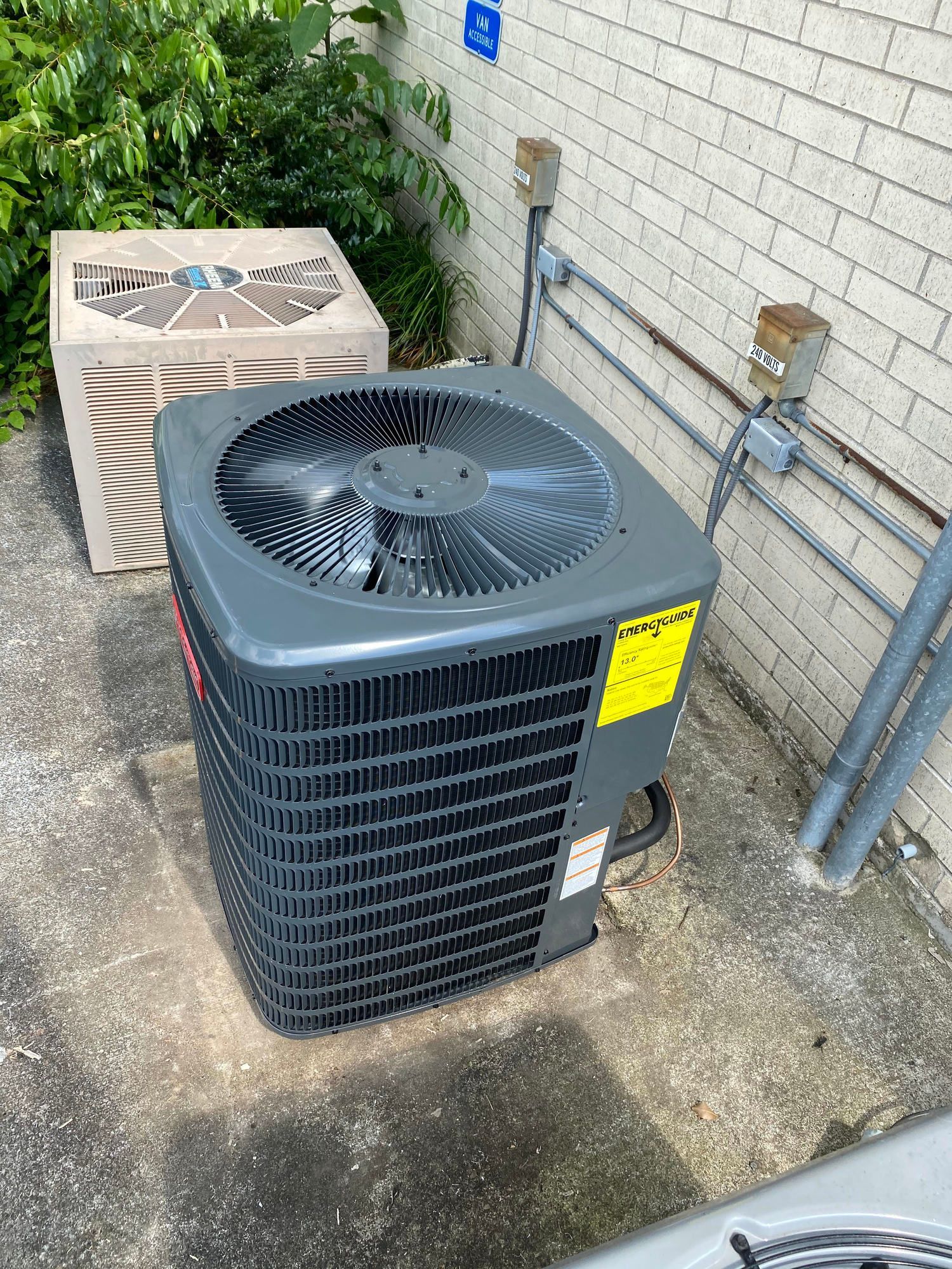 A large air conditioner is sitting on the side of a building.