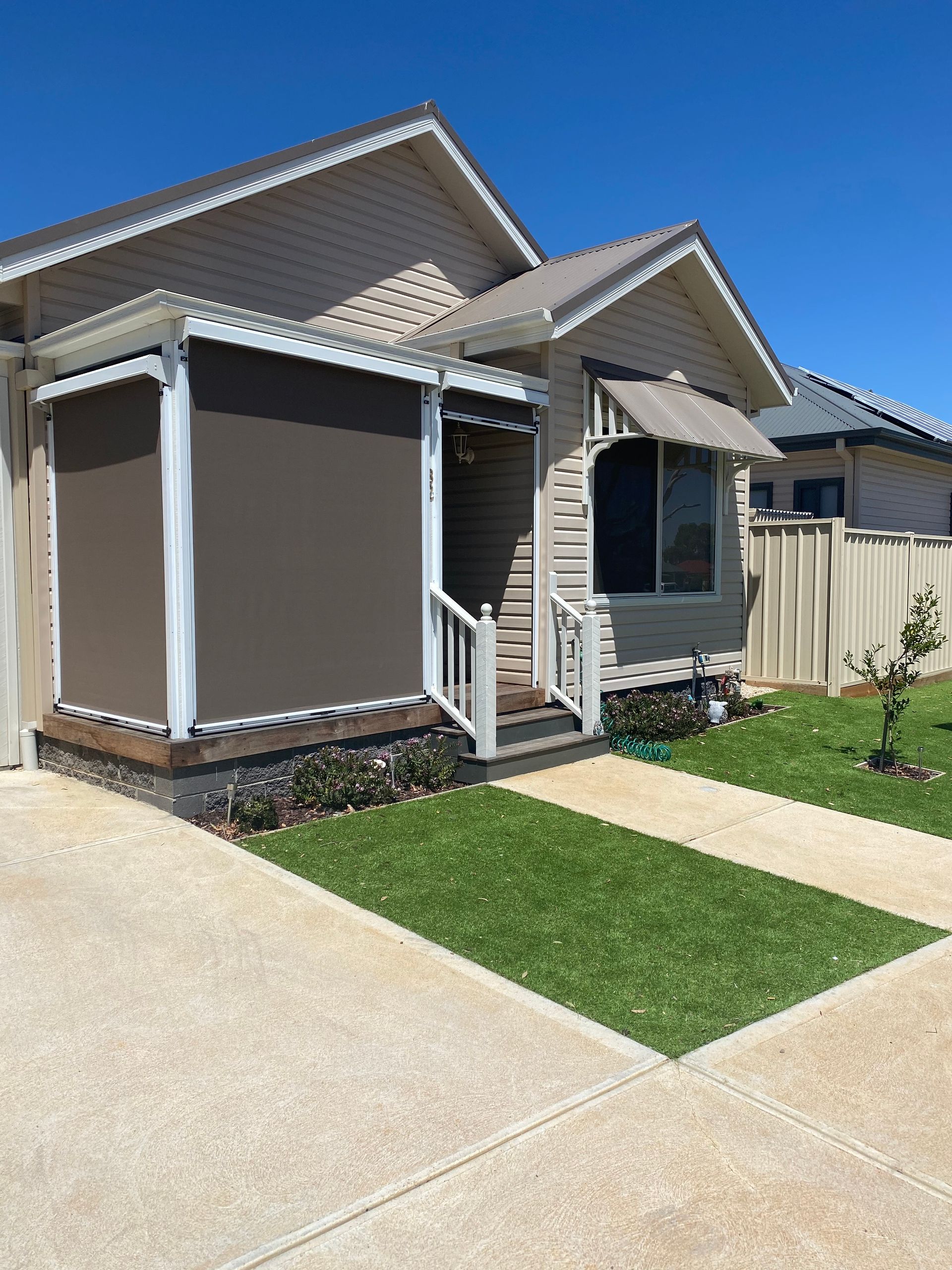 Patio with dining table, couches, and open doors to a modern living room. Bright, sunny day.