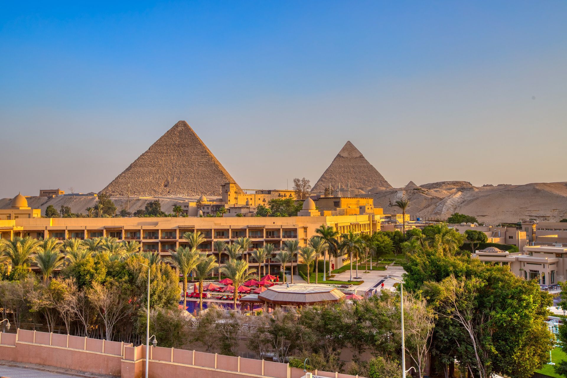 There are two pyramids in the background and a hotel in the foreground.