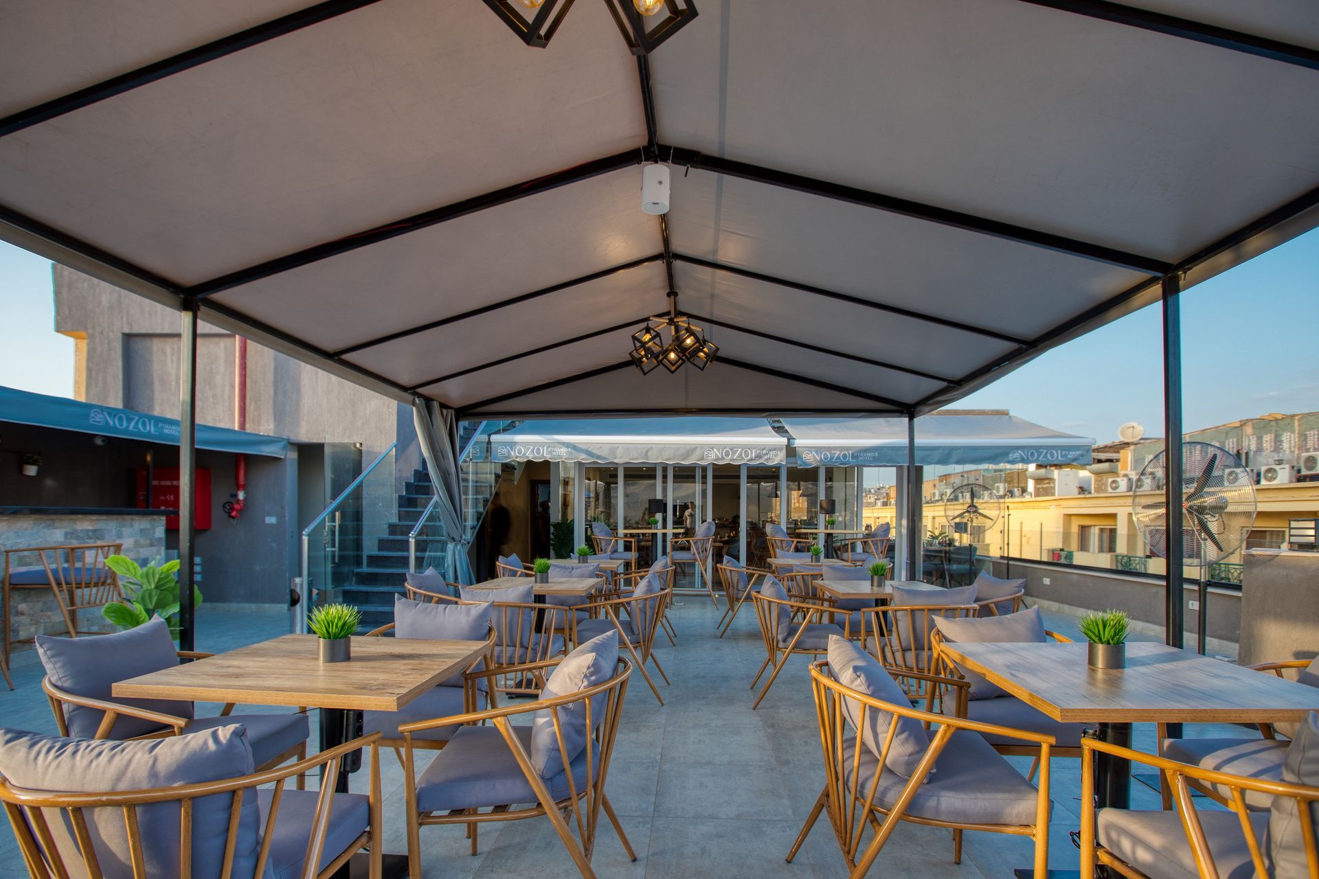 A patio with tables and chairs under a canopy.